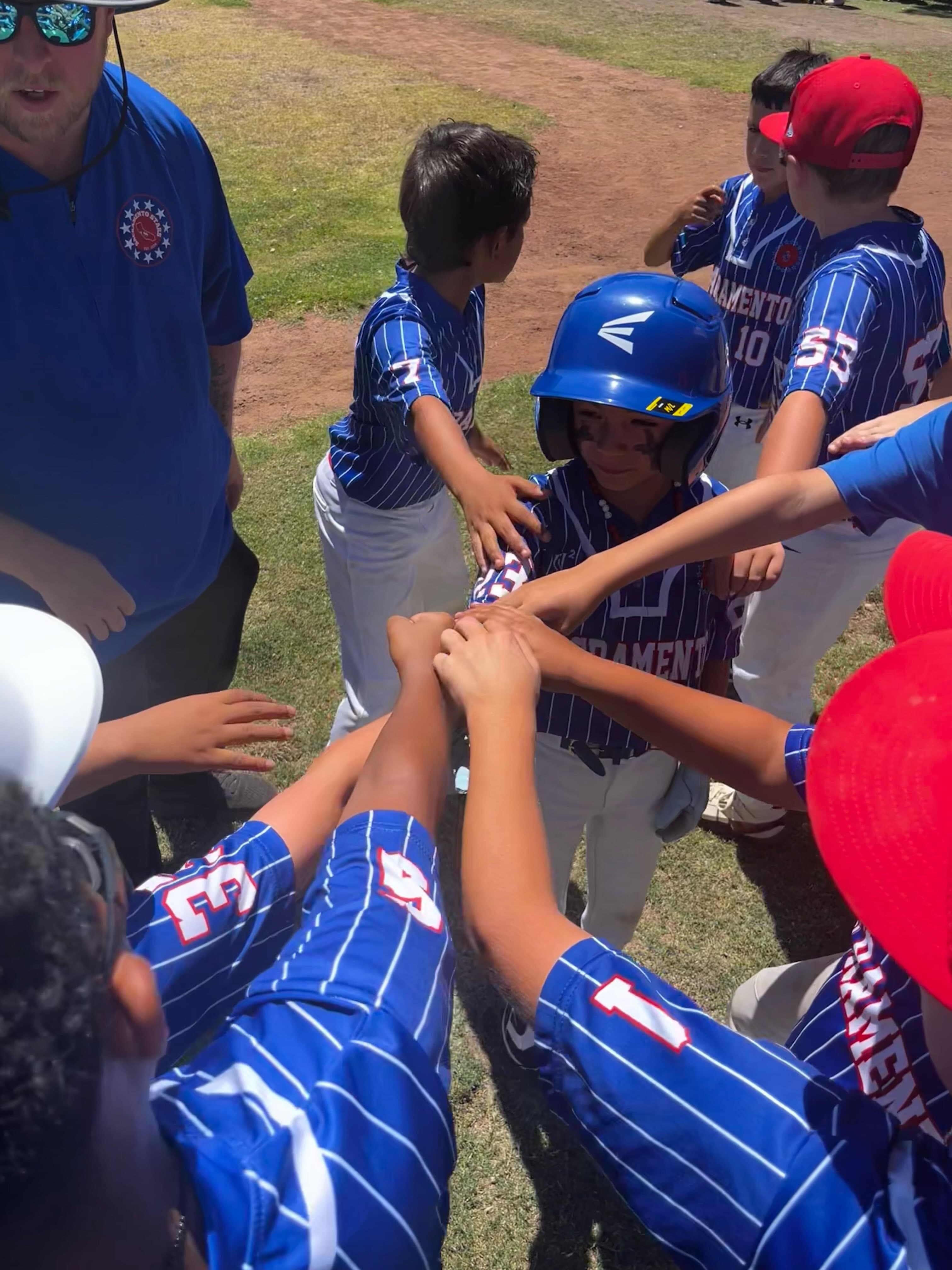 Stars players and a coach put their hands in for a huddle on the field.